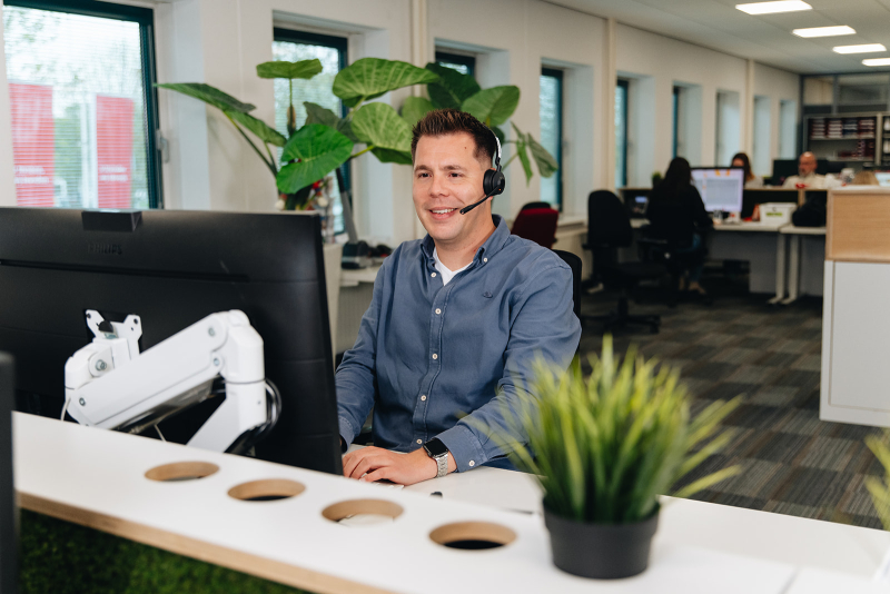 Klantadviseur achter bureau met headset