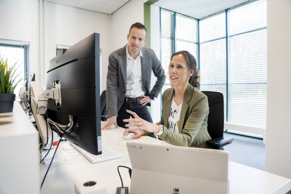 Mannelijke en vrouwelijke medewerker achter bureau